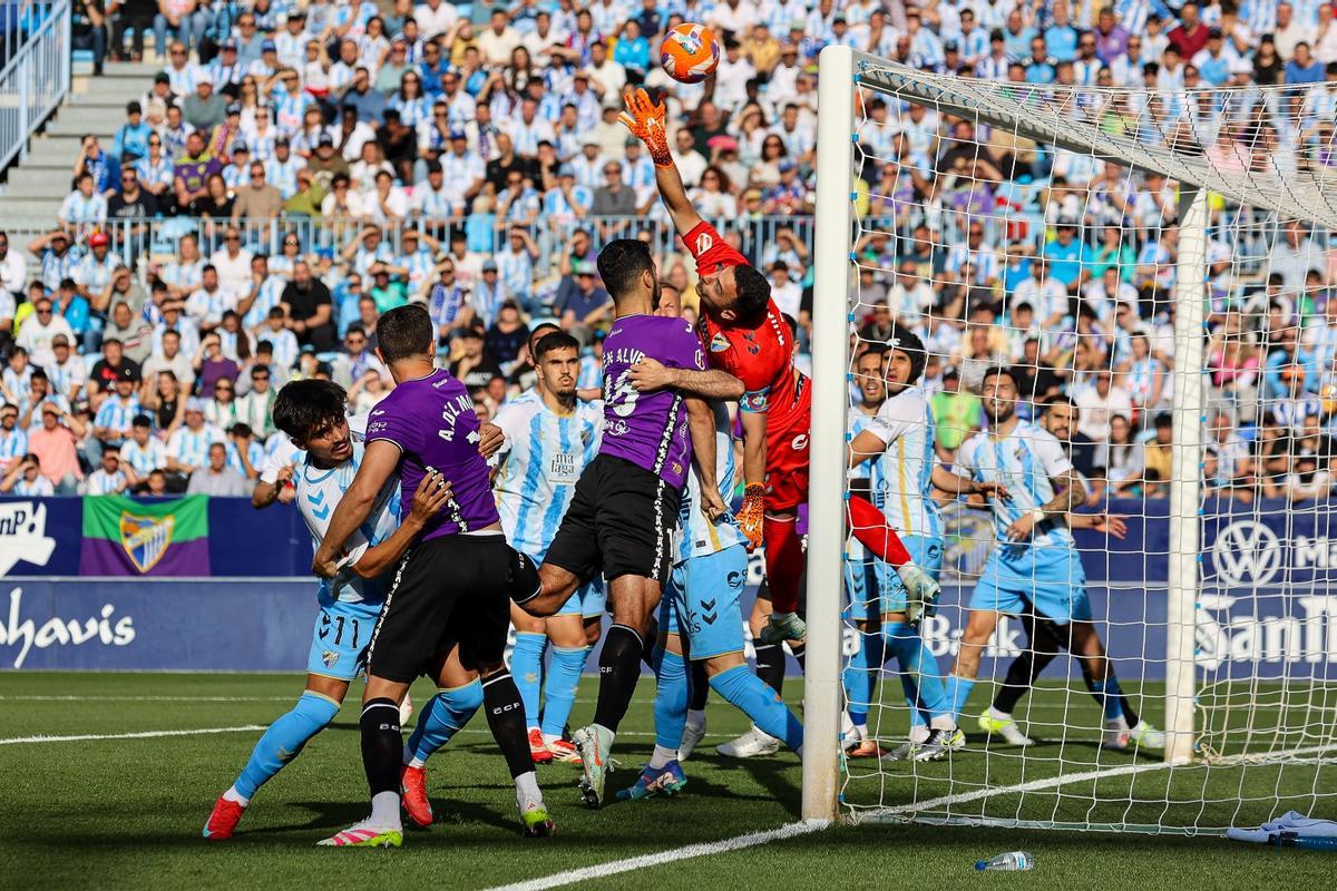 Rubén Alves pugna con Herrero en la disputa de un balón aéreo en el Málaga-Córdoba CF.