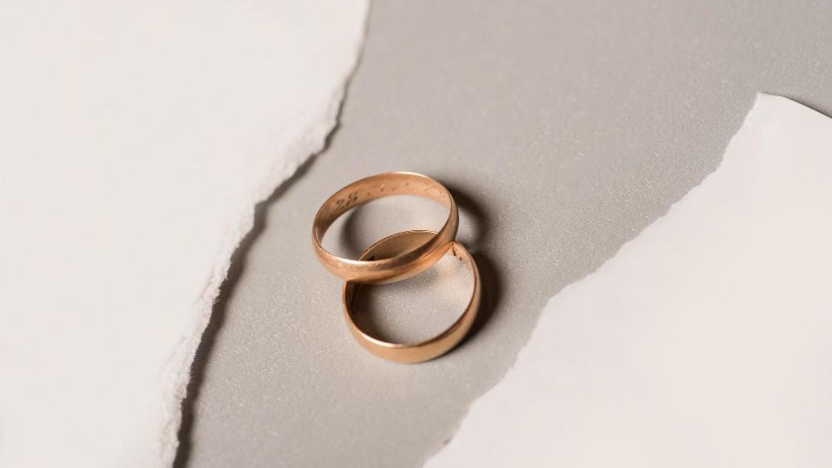 Dos anillos de matrimonio, entre papeles rotos.
