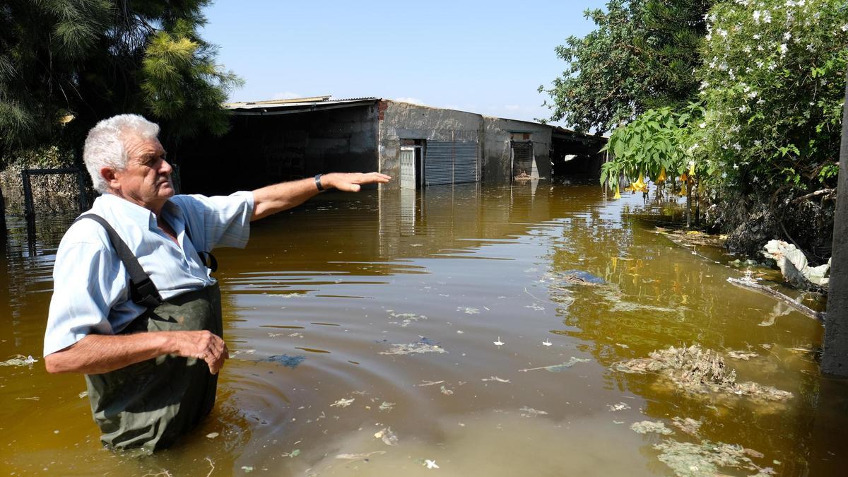 Vicente, metido en el agua hasta la cintura, muestra los estragos que la DANA provocó en sus tierras y su casa