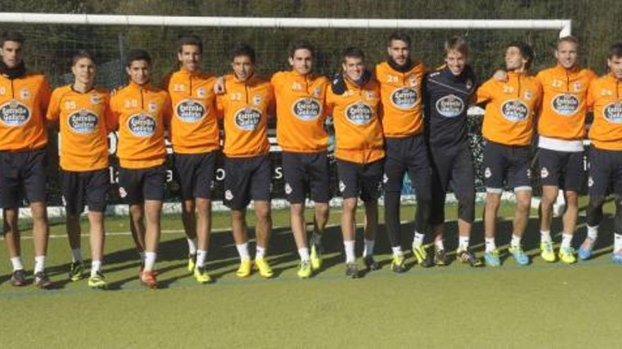 Fernando Vázquez, el primero por la derecha, posa junto a los trece futbolistas gallegos que tuvo a sus órdenes en el entrenamiento de ayer. / víctor echave