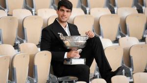 Carlos Alcaraz posa con la Copa de los Mosqueteros de Roland Garros en la grada de la Philippe Chatrier, este lunes.