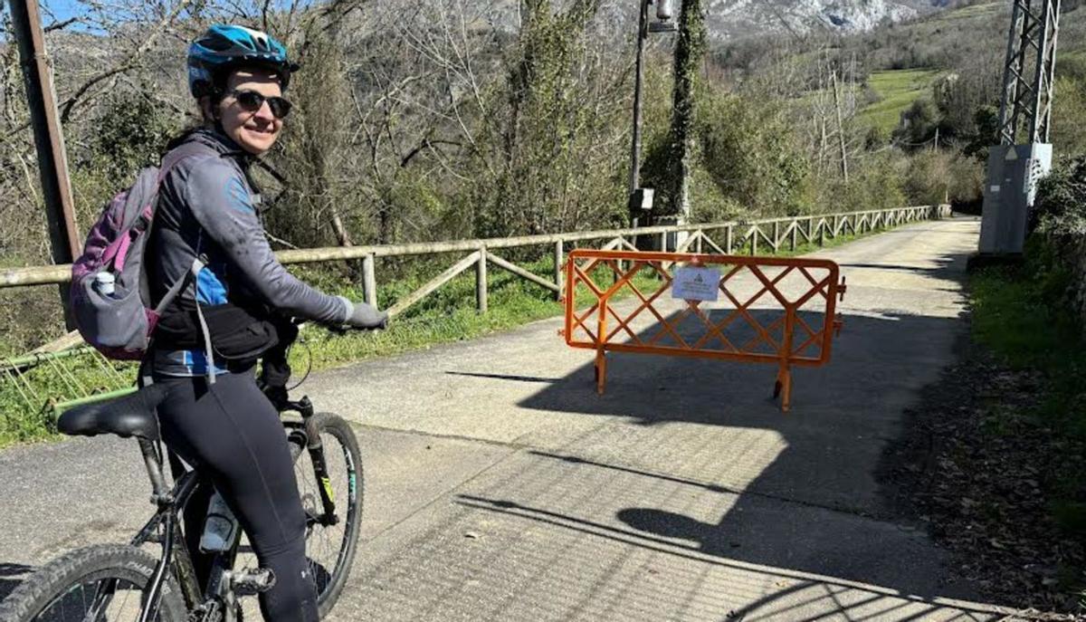 Arriba, Gimena Mijares, ayer, ante la valla que cierra la ruta a los vehículos. A la izquierda, rocas caídas en otro punto de la ruta. | J. A. O.