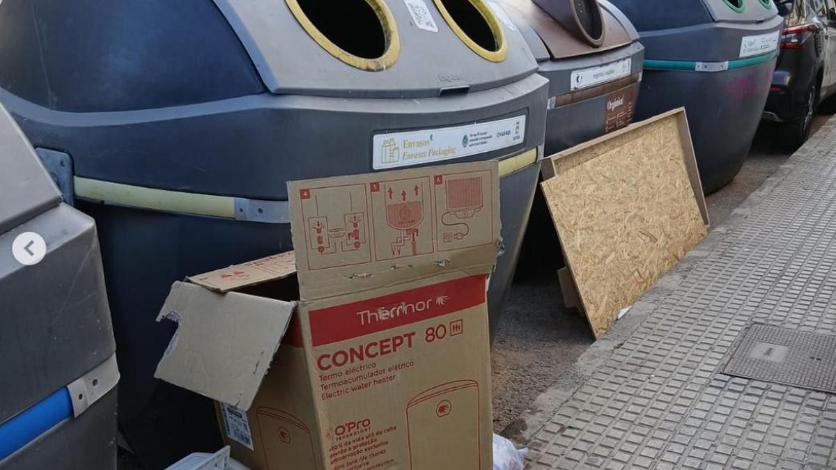 Contenedores de basura con residuos y enseres fuera de lugar