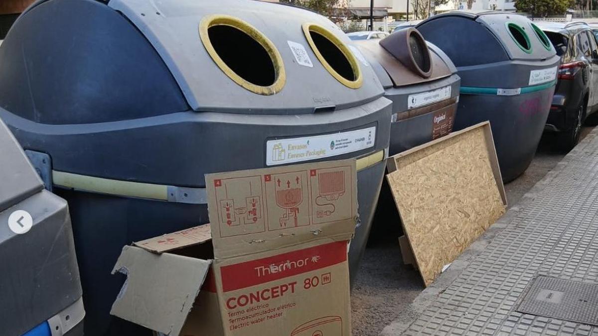 Contenedores de basura con residuos y enseres fuera de lugar.