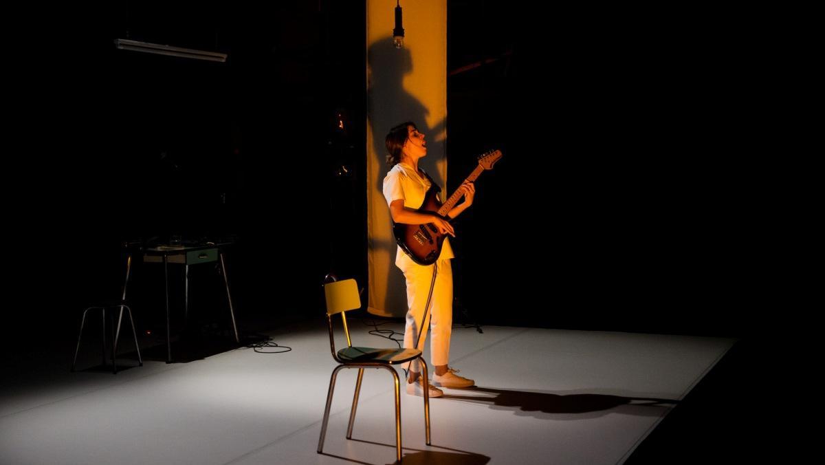 La protagonista canta acompañada por una guitarra eléctrica.