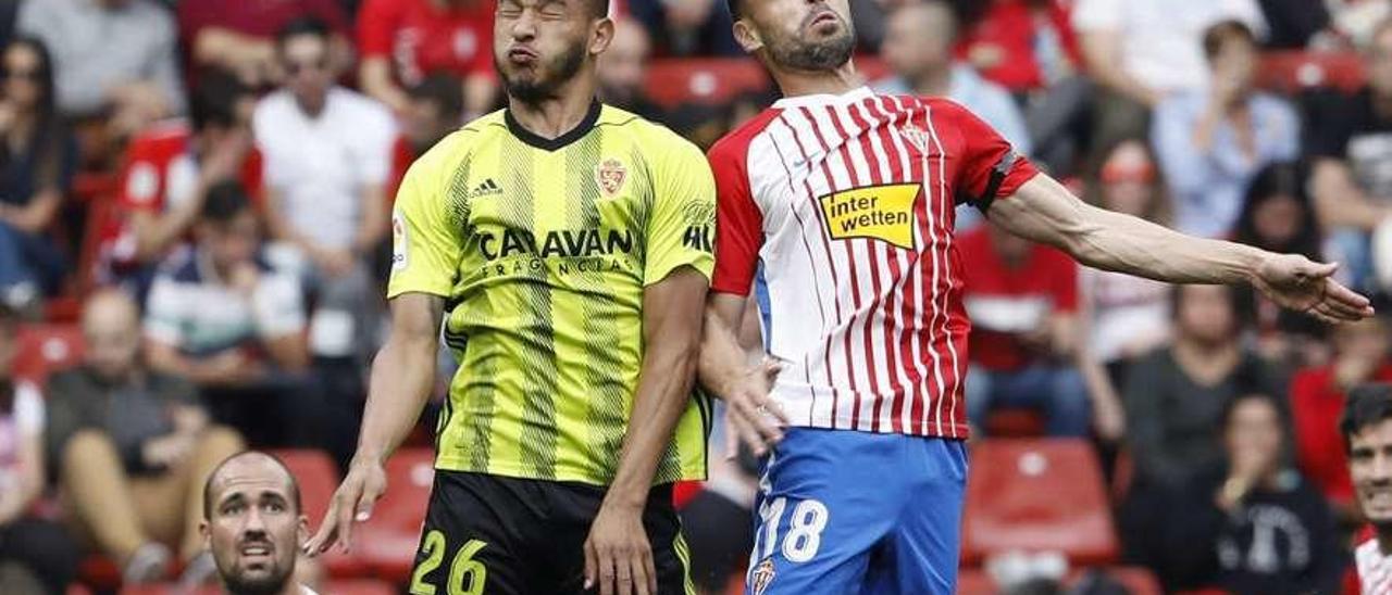 Luis Suárez pelea un balón aéreo con Javi Fuego en el partido de la primera vuelta en El Molinón.