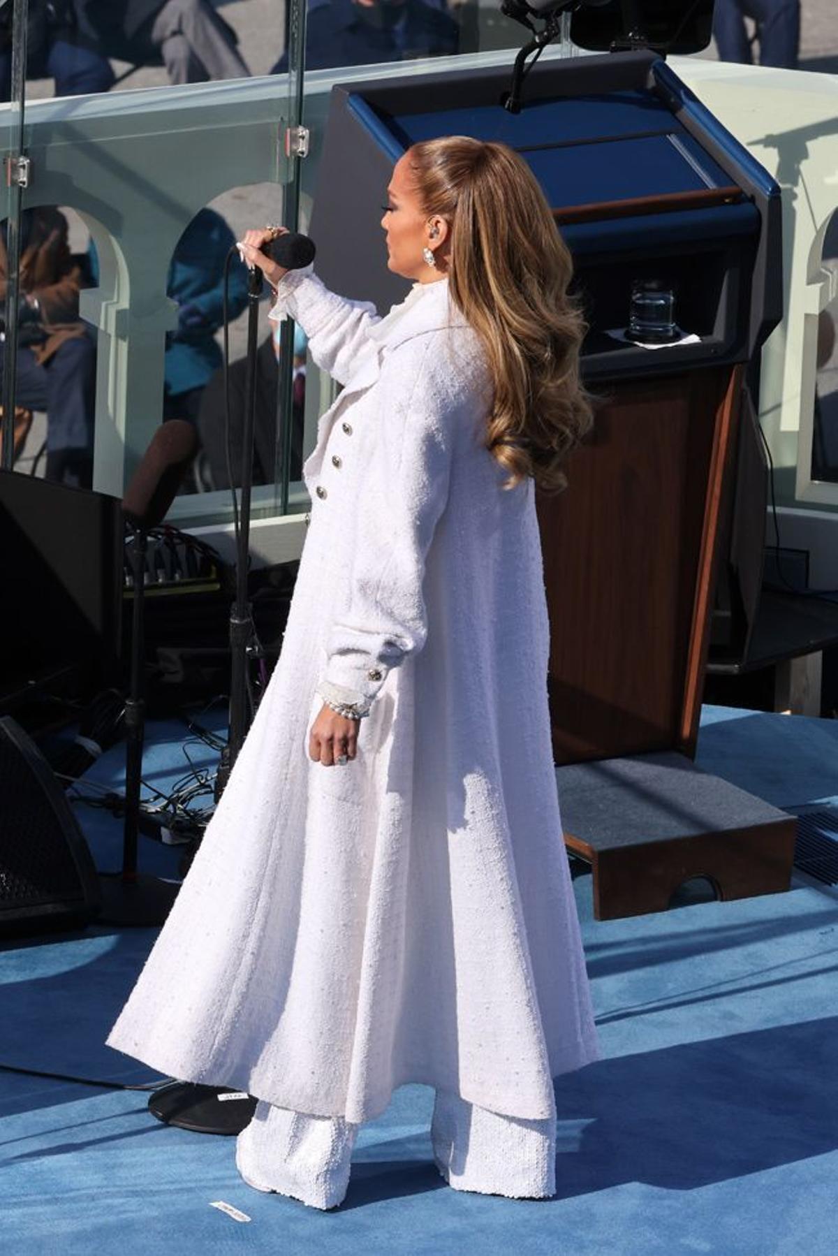 Jennifer Lopez con un look todo en blanco compuesto por pantalones, camisa y abrigo largo en la toma de posesión de Joe Biden como presidente de Estados Unidos