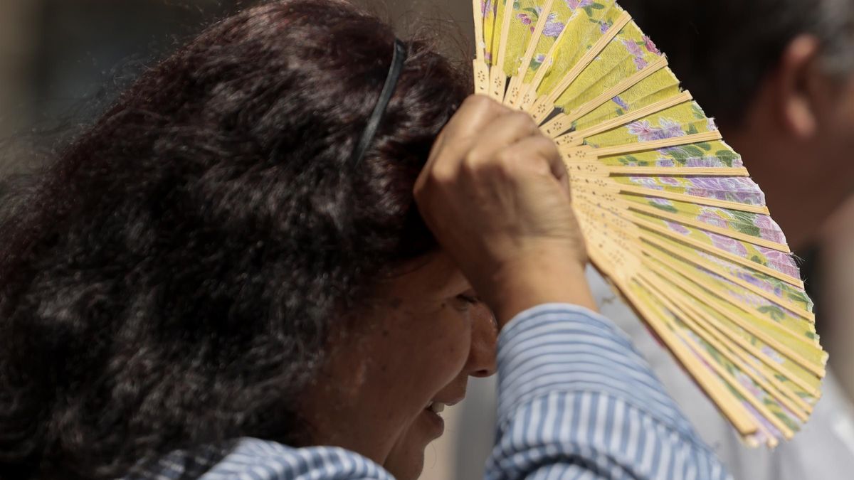 Una mujer se protege con un abanico del calor asfixiante.