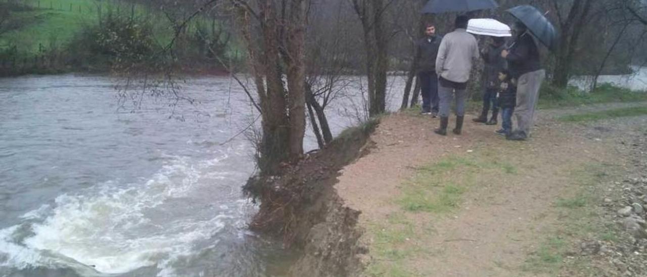 Vecinos de Brieves observan el talud formado por la crecida del río.