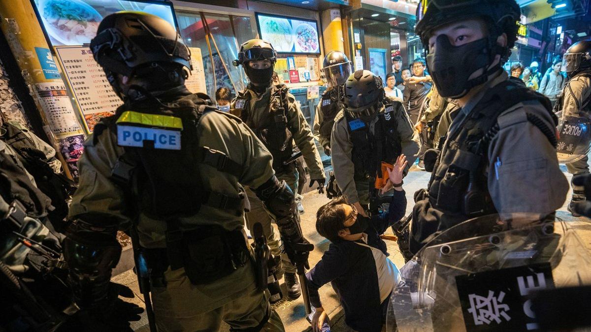 Un grupo de policías arrestan a un manifestante durante una noche de protestas en Hong Kong, el 24 de diciembre del 2019