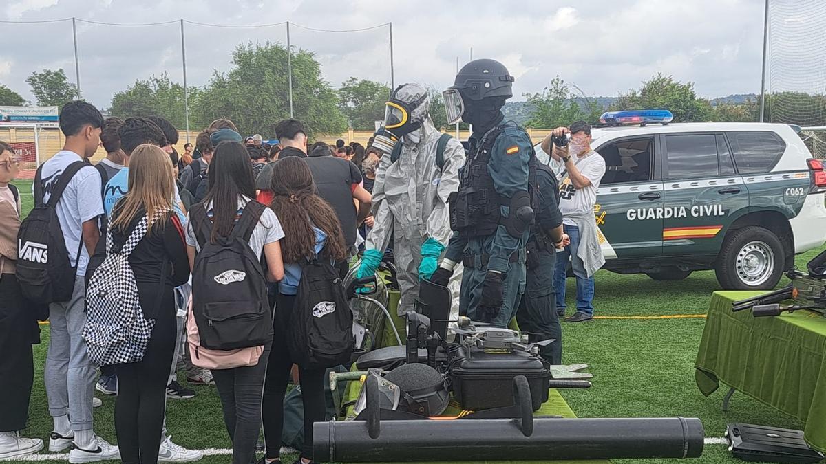 Agentes de la Guardia Civil equipados para misiones especializadas explican su trabajo a un grupo de estudiantes en Palma del Río.