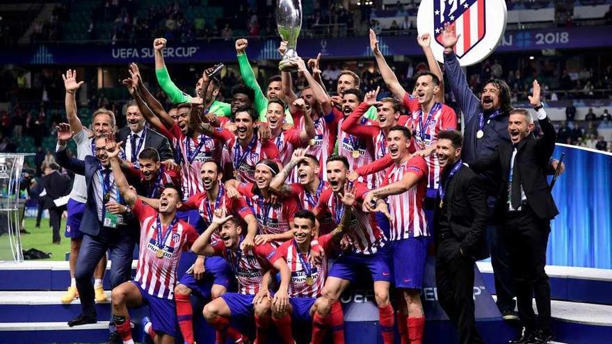 Los integrantes del Atlético celebran la conquista de la Supercopa, que levanta Godín (en el centro).