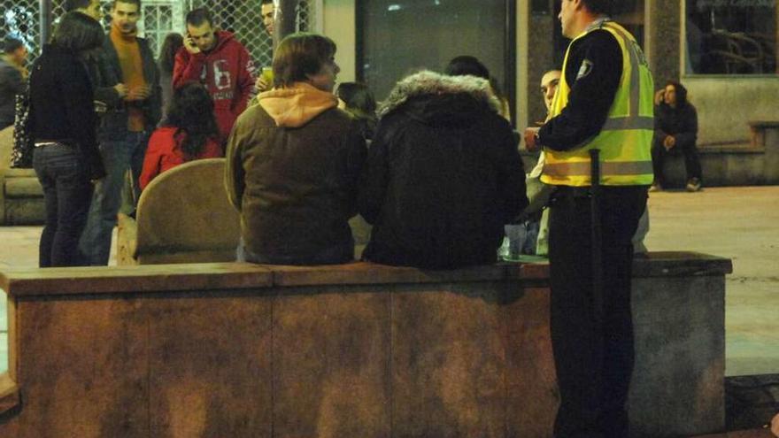 Un policía local habla con menores en una zona de botellón de la ciudad.