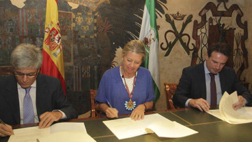 La alcaldesa Ángeles Muñoz, en el centro, firma el acuerdo.