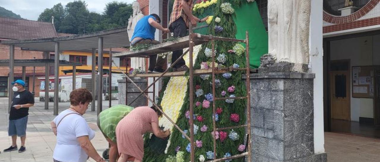 Varios feligreses colocan los claveles en el manto floral de la Virgen de Nuestra Señora de las Nieves en Blimea. | Vivas