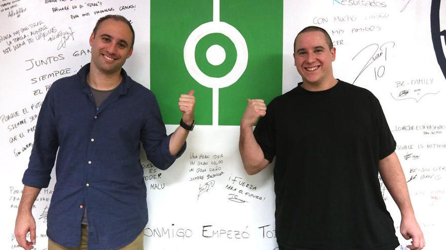 Javier González y Manuel Heredia posan junto al logo de la APP Resultados de Fútbol en la sede de BeSoccer en Málaga