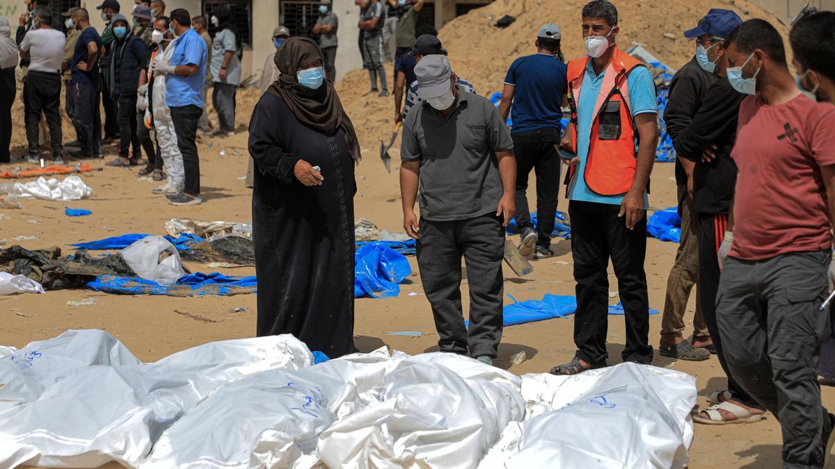 Trabajadores desentierran cadáveres hallados en una fosa común juto al Hospital Nasser de Jan Yunis.