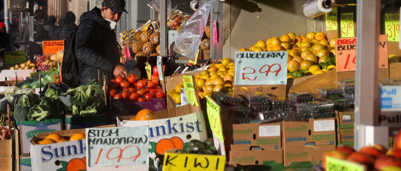 Un joven hace la compra en un puesto de fruta y verdura de Brooklyn.