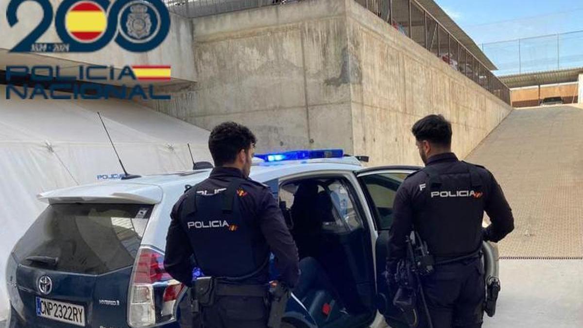 Agentes de la Policía Nacional, junto a su coche patrulla.