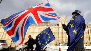 Un contrario al ’brexit’ ondea una bamdera británica junto a otra de la Unión Europea frente al Parlamento británico.