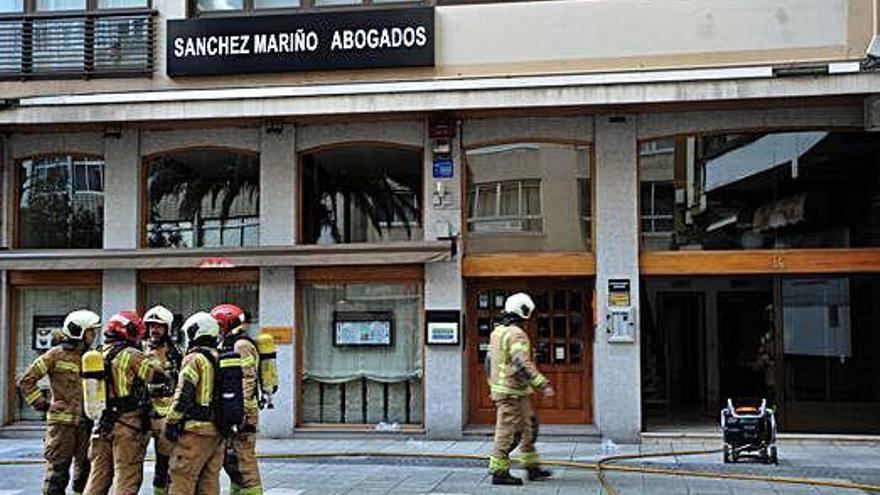 Varios bomberos, ayer, a la entrada del edificio afectado, el número 38 de Juan Flórez.