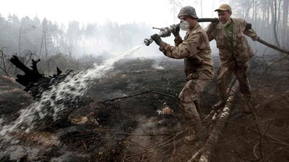Bombers i voluntaris treballen en l’extinció de l’incendi d’un bosc pròxim a Moscou.