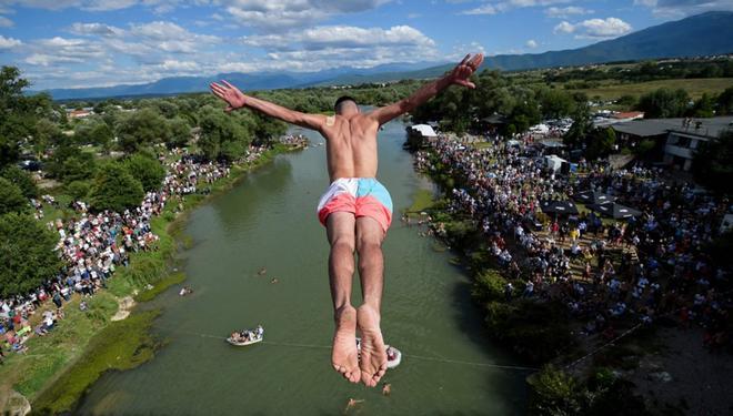 Un buzo salta desde el puente de 22 metros de altura Ura e Shenjte, como señal de protesta después de que la policía cancelara la 70ª competencia anual tradicional de buceo de altura en el puente, cerca de la ciudad de Gjakov.