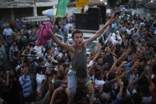 Ciudadanos palestinos celebran en las calles de Gaza el alto el fuego.