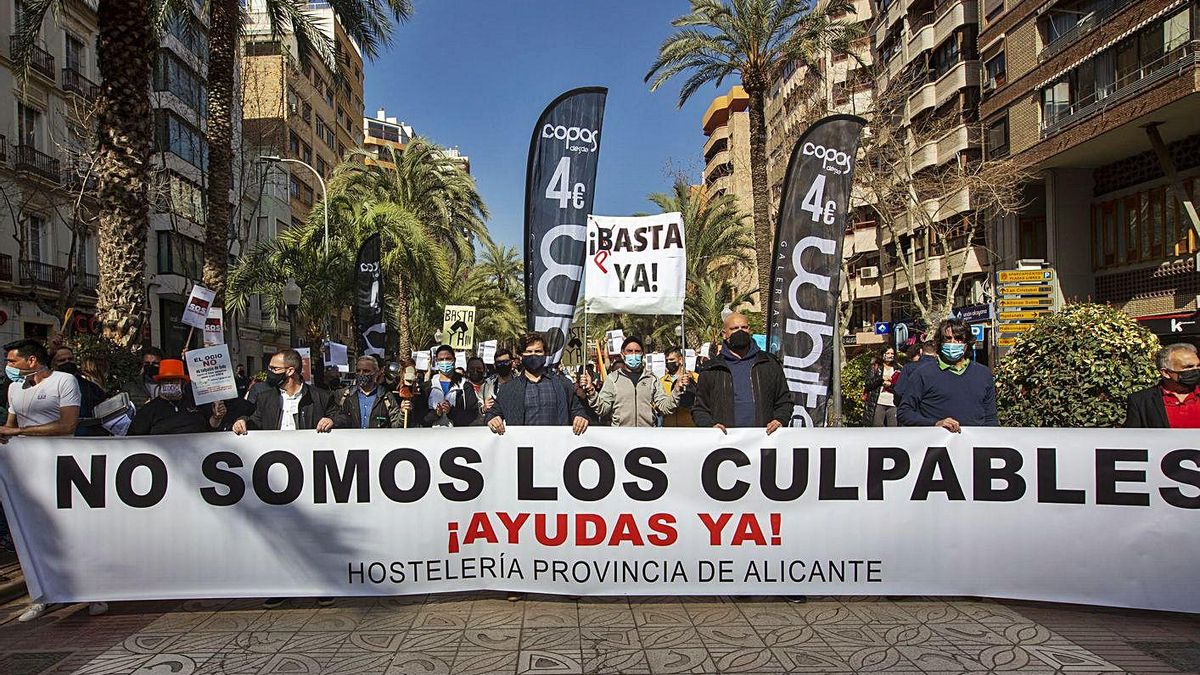Above, the main banner of the protest with a saucepan, and below, hoteliers with bills. | RAFA ARJONES Above, the main banner of the protest with a saucepan, and below, hoteliers with bills. | RAFA ARJONES