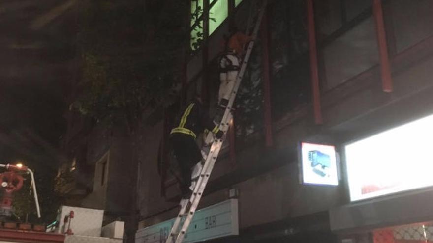 El afectado -centro-, con pantalón blanco, baja con los bomberos.