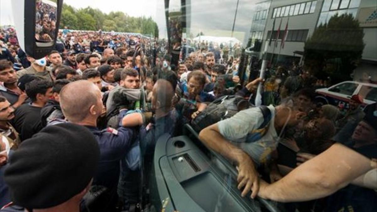 Refugiados suben a un autocar cerca de Heiligenkreuz, en la frontera entre Austria y Hungría, ayer.