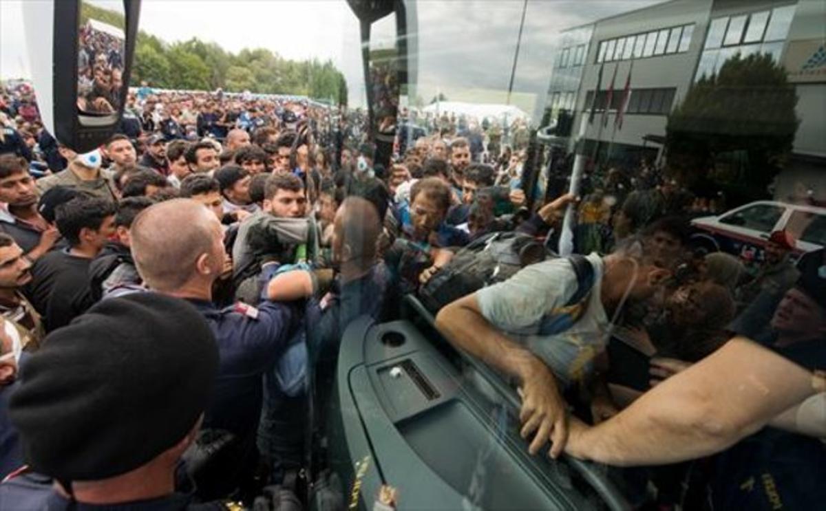 Refugiats pugen a un autocar a prop de Heiligenkreuz, a la frontera entre Àustria i Hongria, ahir.