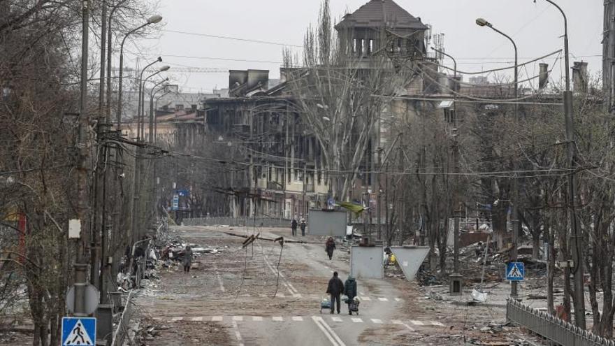 Ciutadans caminant ahir per l&#039;assetjada ciutat de Mariúpol, on no hi ha llum o gas després dels bombardeigs russos