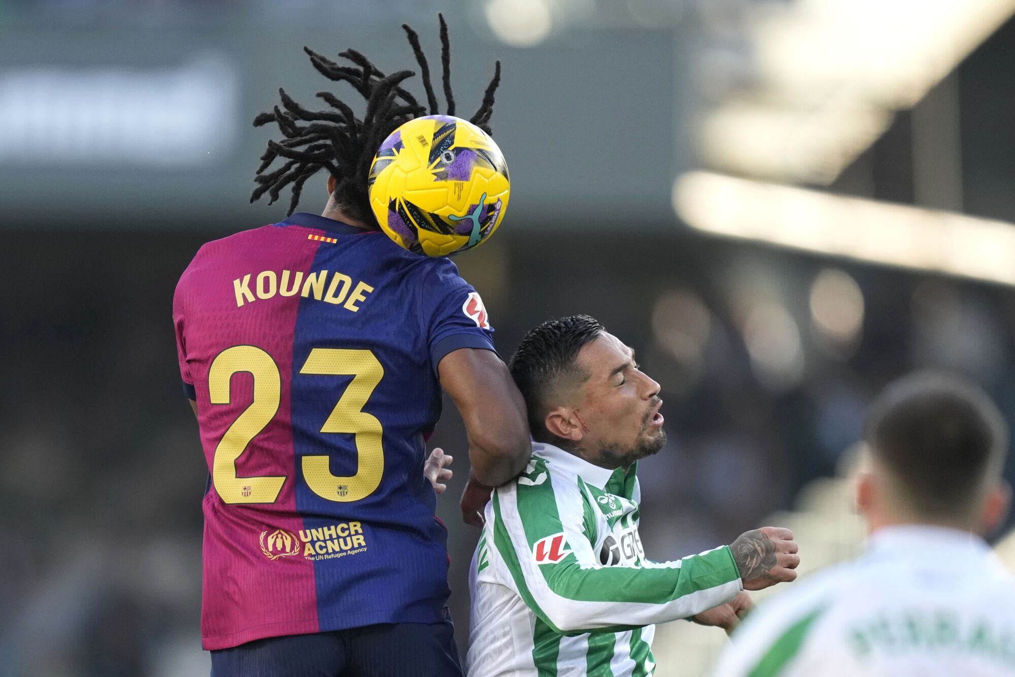 Barcelona's Jules Kounde, left, challenges for the ball with Betis' Chimy Avila during a Spanish La Liga soccer match between Betis and Barcelona at the Benito Villamarin stadium in Seville, Spain, Saturday, Dec. 7, 2024. (AP Photo/Jose Breton). EDITORIAL USE ONLY/ONLY ITALY AND SPAIN