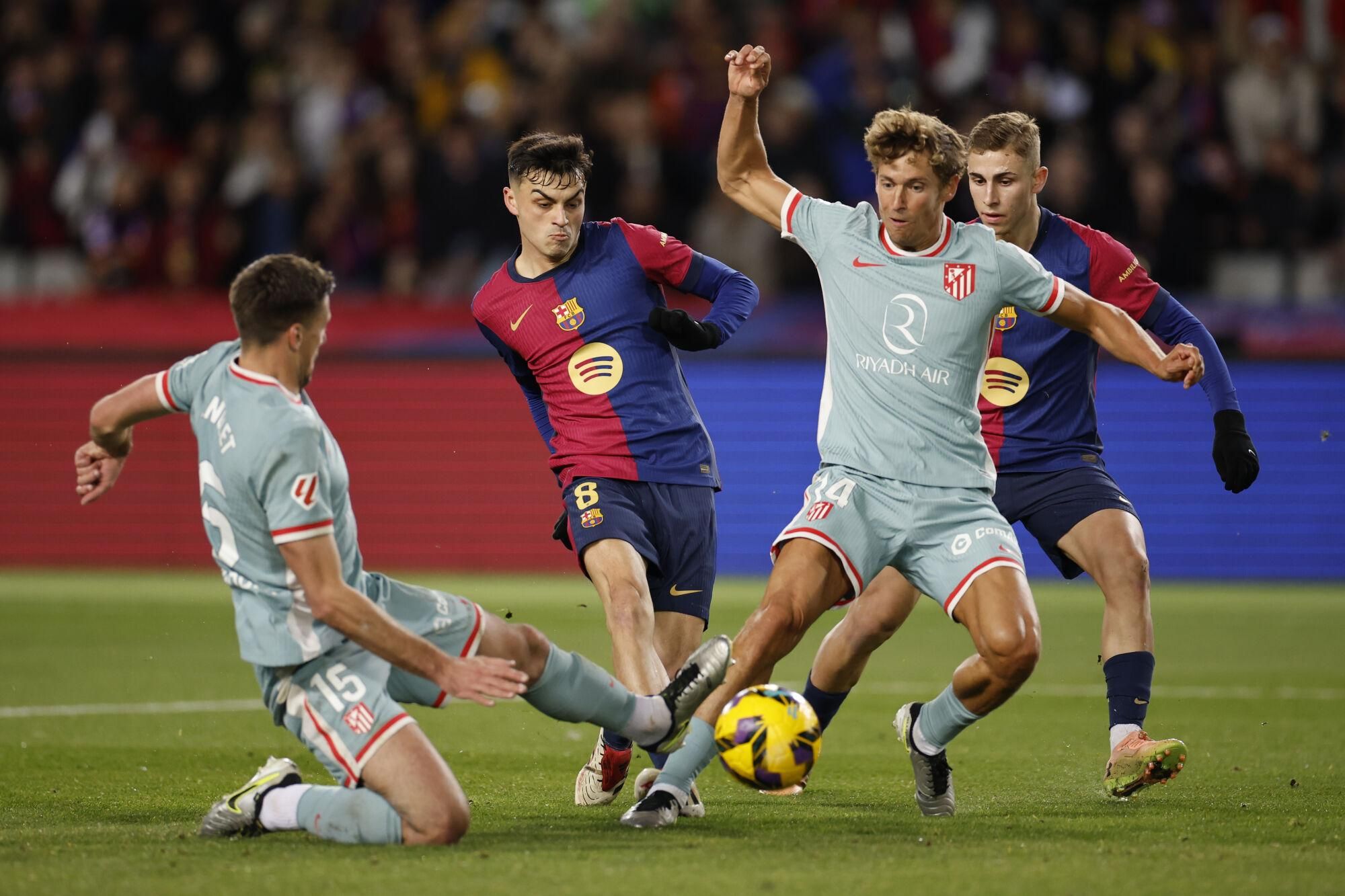 BARCELONA, 21/12/2024.- El centrocampista del FC Barcelona Pedri (2i) intenta un lanzamiento, durante el partido de la jornada 18 de LaLiga entre el FC Barcelona y el Atlético de Madrid, este sábado en el estadio olímpico Lluis Companys. EFE/Alberto Estévez