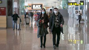 Ya hay siete pacientes más en España contagiados con el coronavirus. En la foto, pasajeros con mascarillas en el aeropuerto de El Prat.