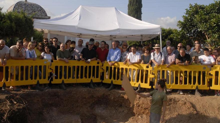 Una arqueóloga explica a los vecinos y políticos presentes el proceso de exhumación, hoy por la tarde en Marratxí.