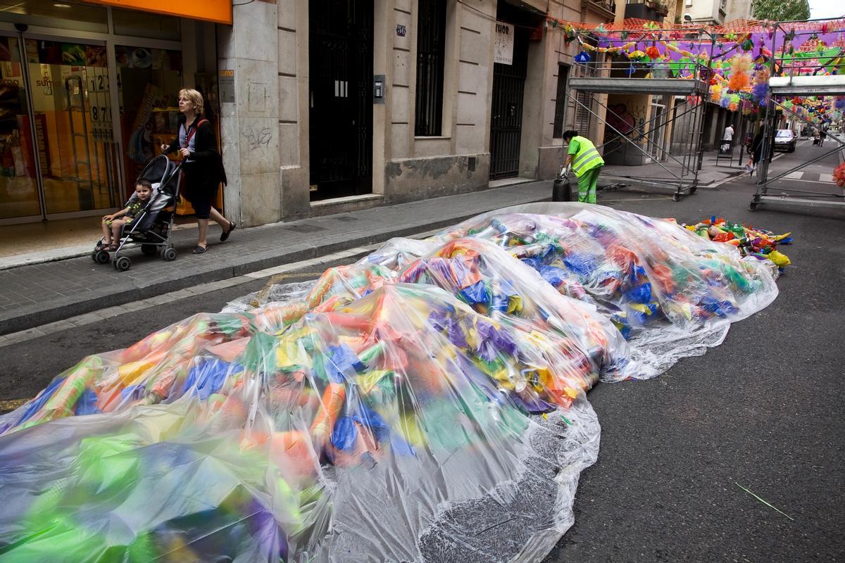 Una de las calles decoradas de Gràcia, con protección de plástico frente a la lluvia en 2010