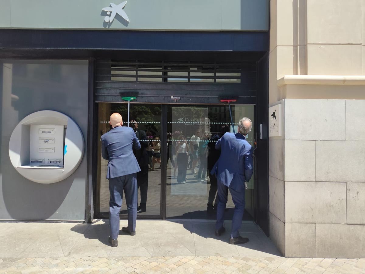 En la Caixa tuvieron que ayudarse con escobas para poder cerrar su sucursal.