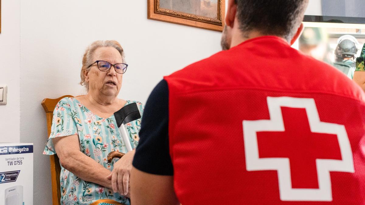 Alguien de Cruz Roja hablando con una anciana.