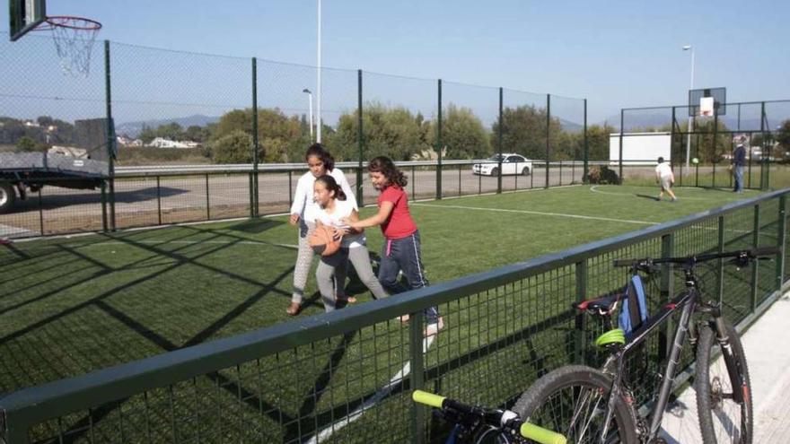 Unas niñas practican baloncesto, ayer, en la nueva cancha de césped artificial de A Ladeira. // José Lores