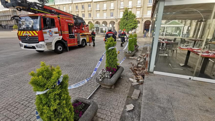 Los bomberos acuden a la plaza de María Pita a reparar el friso decorativo de la terraza de la pizzería Cambalache