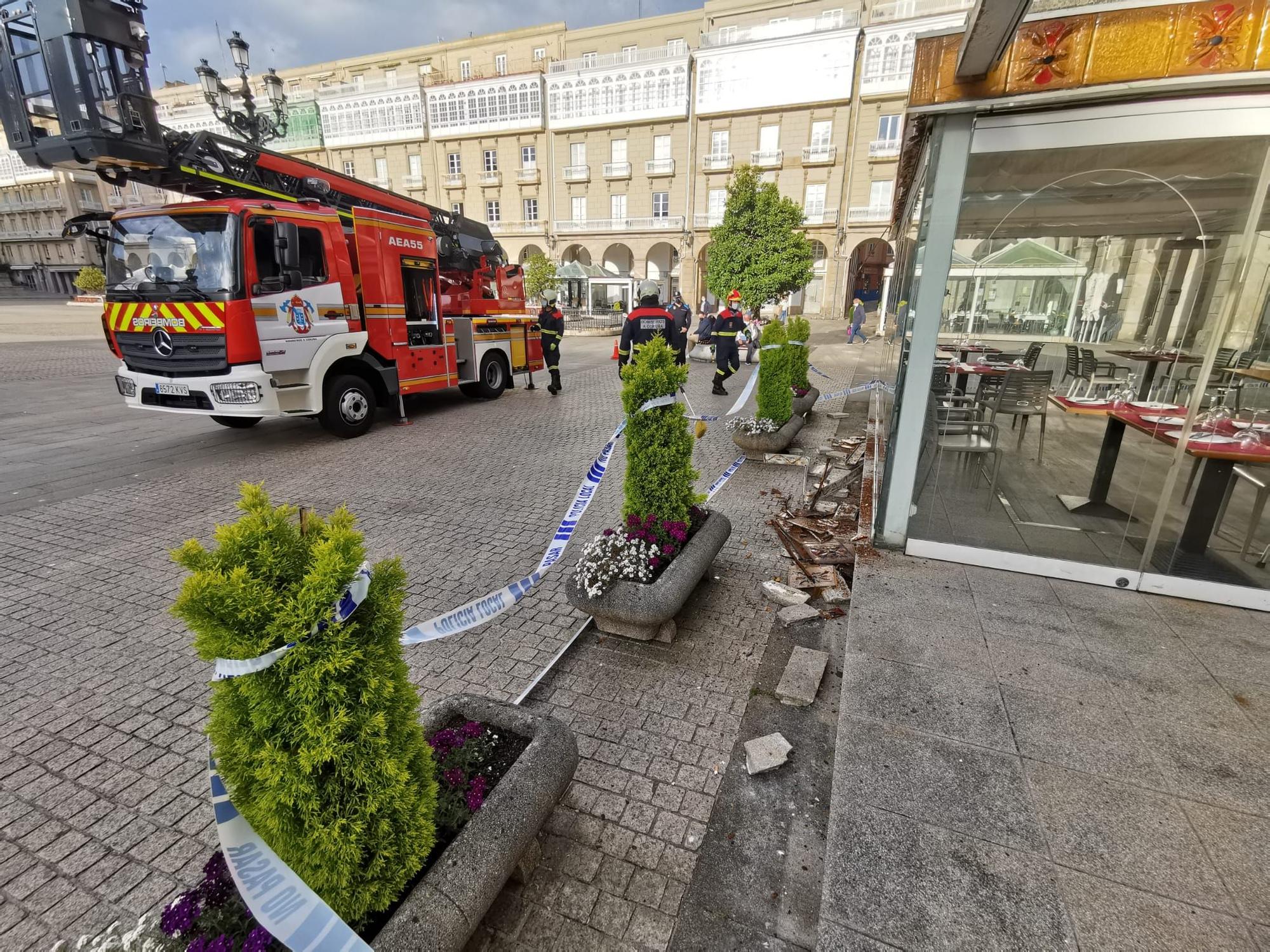 Los bomberos acuden a la plaza de María Pita a reparar el friso decorativo de la terraza de la pizzería Cambalache