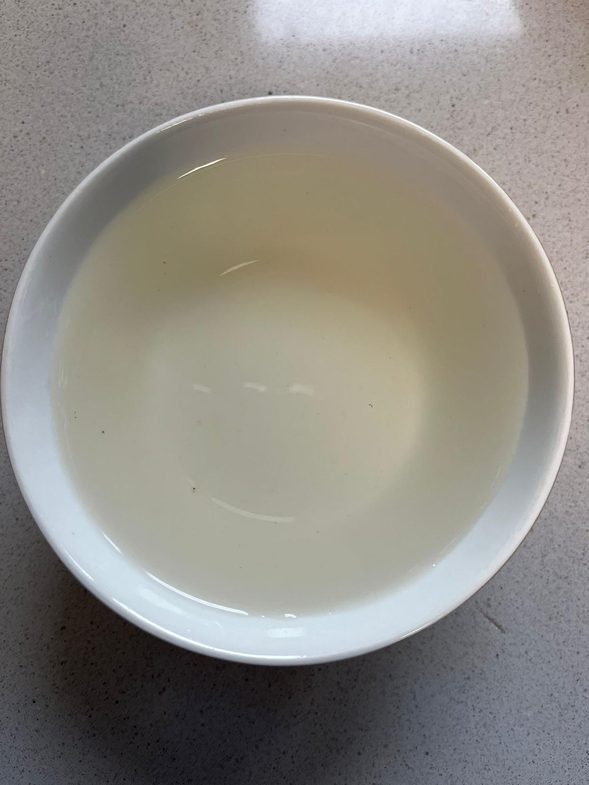 Tazón de agua turbia de un grifo de Cubelo