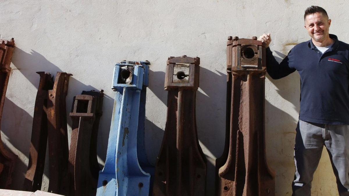 Miquel Ramis mit wuchtigen Bauteilen aus Gusseisen, den „braços del caixó“, die für die Restaurierung bereitstehen.   | FOTO: NELE BENDGENS