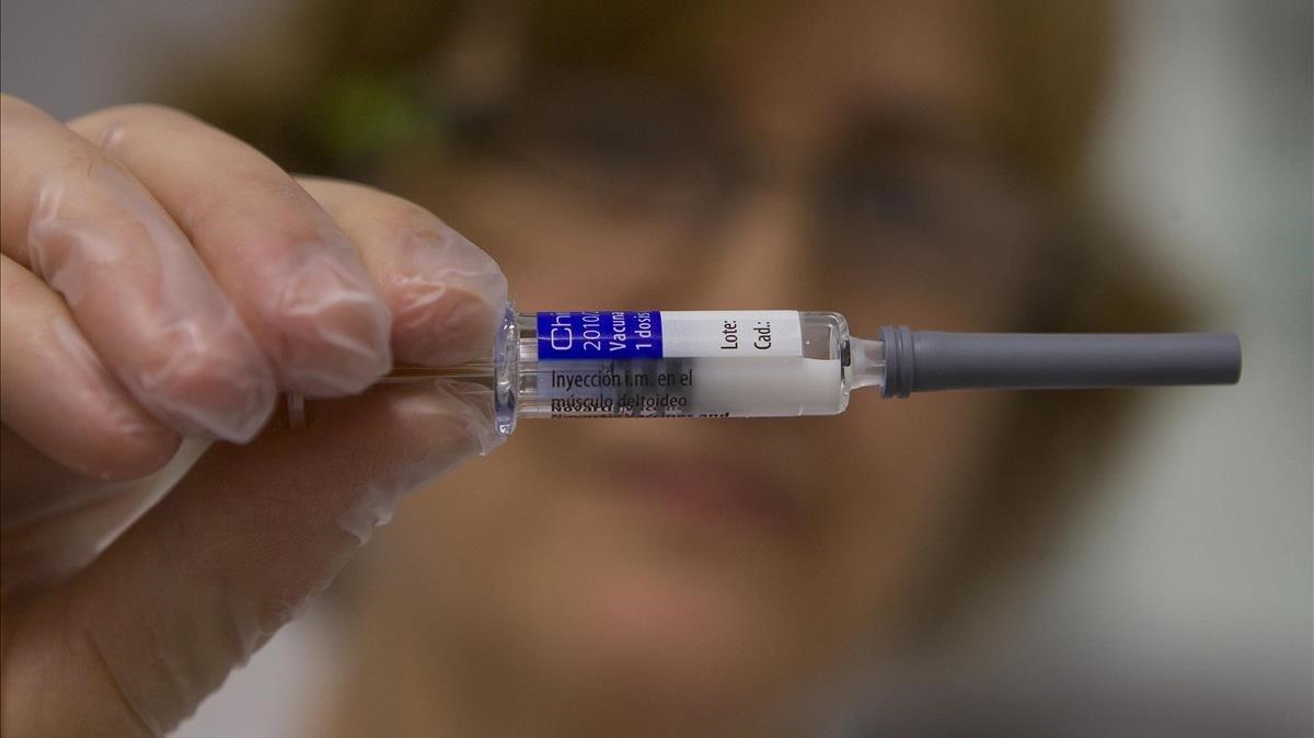 Una profesional sanitaria muestra una vacuna contra la gripe, en una imagen de archivo