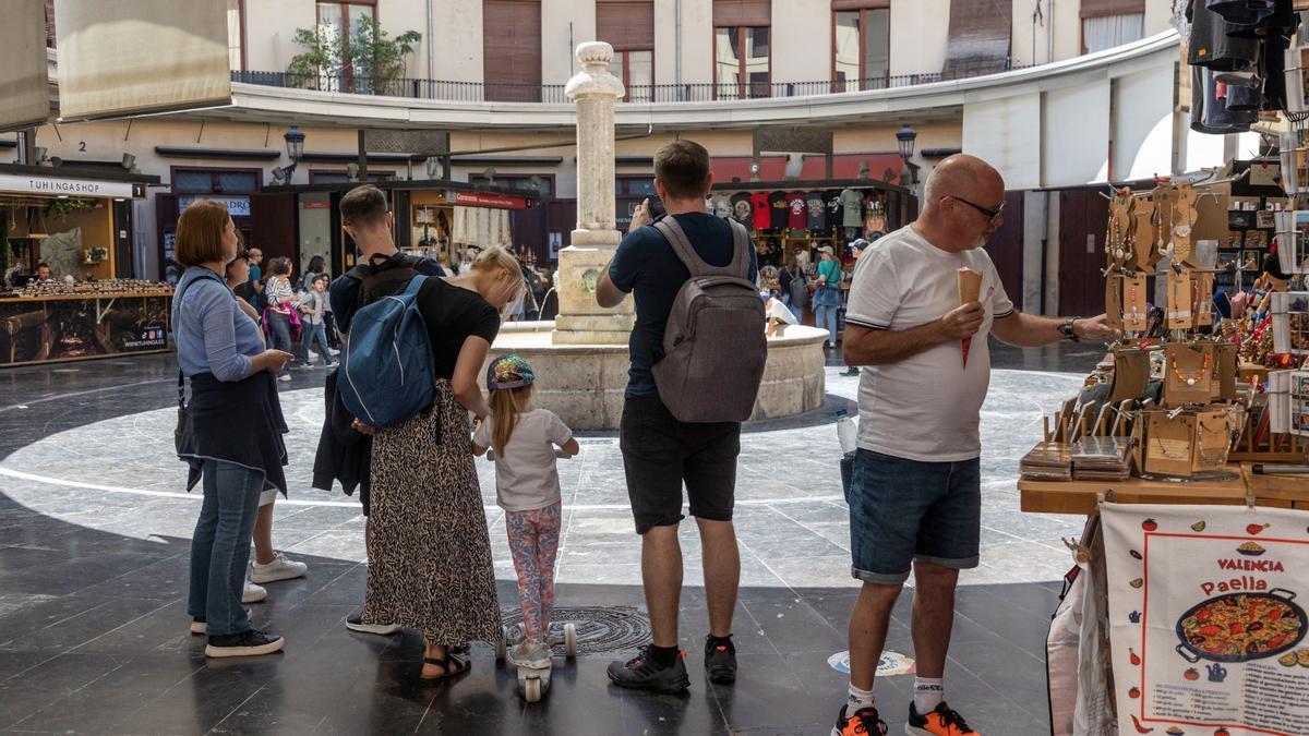 Unos turistas fotografían la plaza Redonda en València