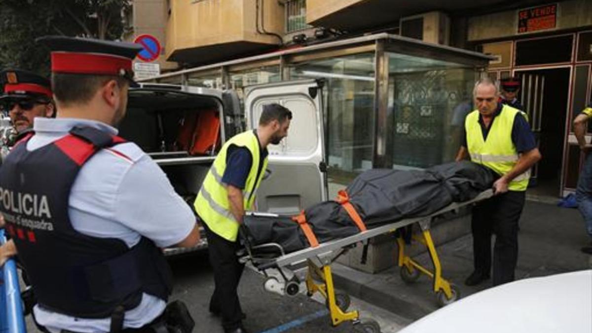 Traslado del cuerpo de uno de los fallecidos, este domingo en Santa Coloma.