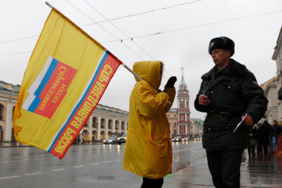 Un funcionari parla amb un militant del partit ’Rússia Justa’ a Sant Petersburg. Les eleccions legislatives russes se celebraran aquest diumenge.