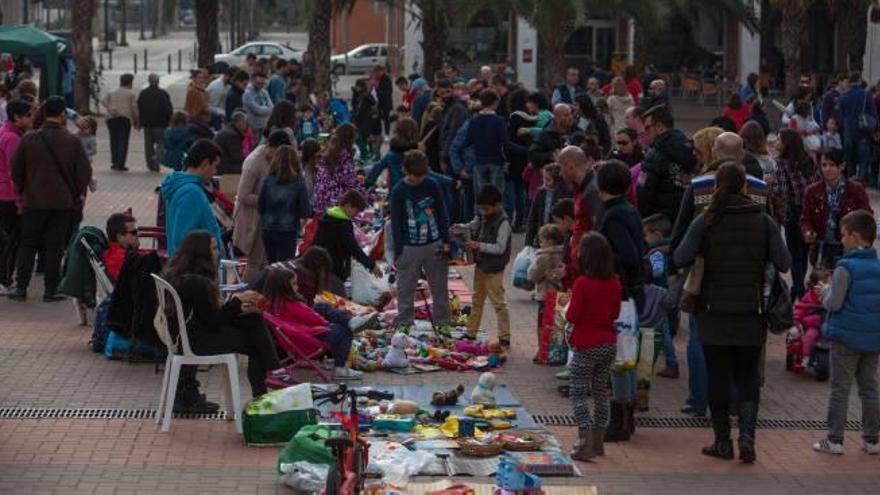 Los visitantes al mercado del trueque pasean entre los puestos de la plaza de Castilla.